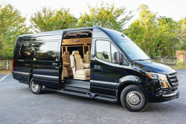 Luxury black RV rental van with its side door open, revealing a plush tan interior and comfortable seating.. Ultimate Toys Ultimate Coach 2022