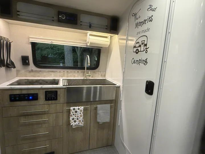 RV rental kitchen: Organized interior with sink, cooktop, controls, and space-saving storage. Great for camping trips.. InTech RV SOL 2021