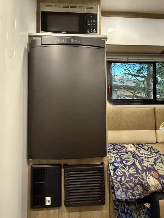 Inside a functional RV rental: features a compact kitchen with microwave, Dometic refrigerator, and a cozy dinette.. InTech RV SOL 2021