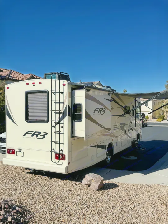 Cream FR3 RV rental parked. Its slide-out and awning are extended, ready for travel on a clear sunny day.. FR3 FR3 Motorhome 2018