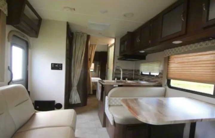 Inside this RV rental: a modern kitchen, comfortable dinette with booth seating, and bright living space with sofa. Ready for adventure.. Coachmen Freelander 2018