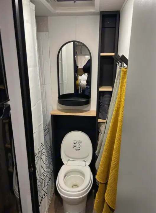 Step inside this RV rental's compact bathroom: a bright white toilet, sleek mirror, & clever storage for towels.. Forest River Cherokee Wolf Pup 2022