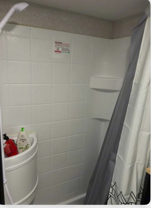 RV rental: Compact white shower stall with handheld sprayer, built-in shelves, and small sink for toiletries.. Forest River Cherokee Wolf Pup 2022