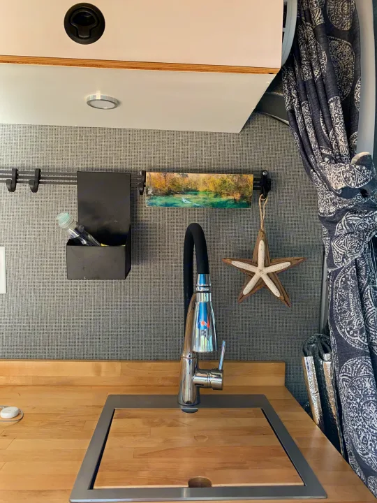 This RV rental offers a well-designed kitchen, with a chrome faucet, wooden counter, and organized wall storage options.. Ford Custom Transit 2019