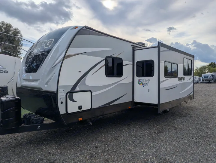 Light gray MPG Ultra-Lite travel trailer with an extended slide-out, parked on gravel. Perfect for rv rental adventures!. Cruiser RV MPG Ultra Lite 2019