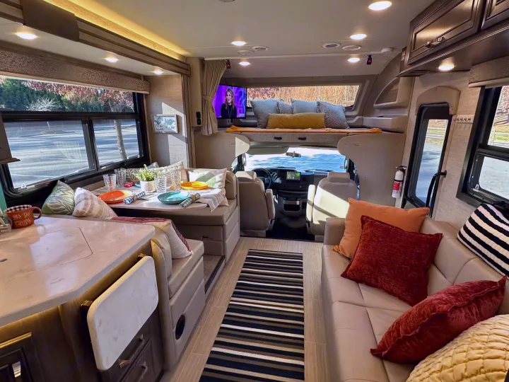 Spacious, modern RV rental interior featuring a living area, kitchen, dinette, and cab-over bunk bed for comfortable travel.. Entegra Coach Esteem 2023