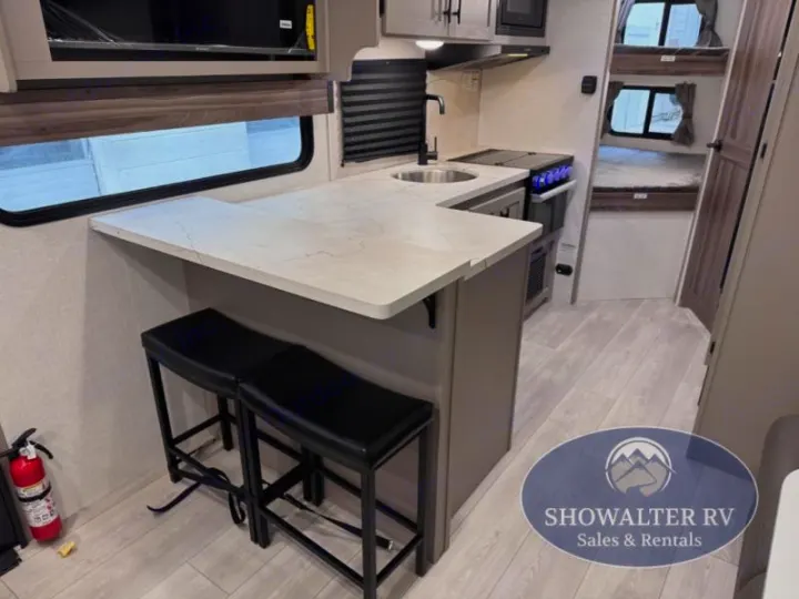 Inside a modern RV rental: compact kitchen, bar seating, and bunk beds create a functional, cozy space for travel.. K-Z Manufacturing Connect Mini 231BH 2025