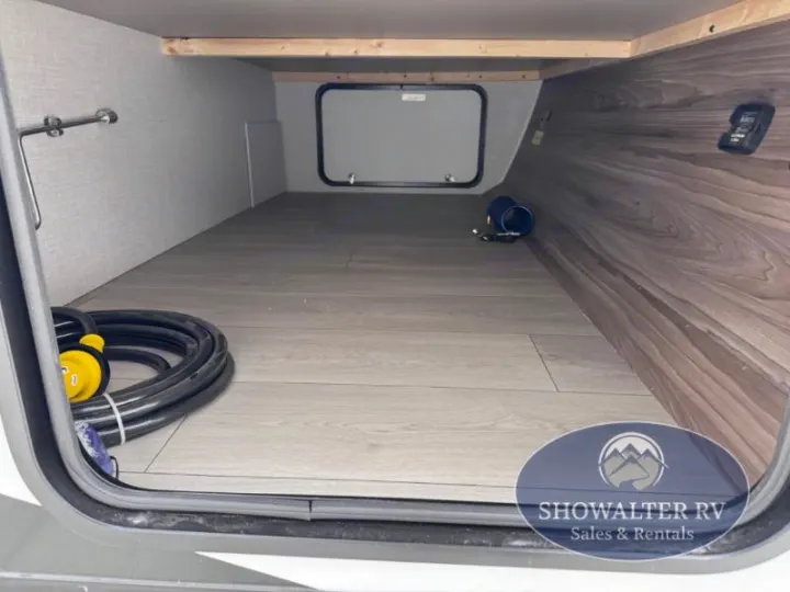 RV rental pass-through storage: a large compartment with wood-look floor, ideal for gear like the electrical cord.. K-Z Manufacturing Connect Mini 231BH 2025