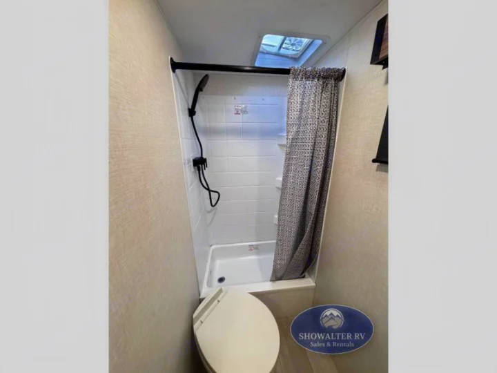 Compact RV bathroom featuring a shower, toilet, and skylight—ideal for your next rv rental.. K-Z Manufacturing Connect Mini 231BH 2025