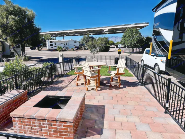 Paved rv rental site with a fire pit, patio dining set, and an RV parked. Great for a comfortable RV park stay.. Fleetwood Bounder 33C 2021