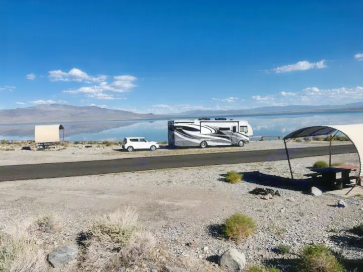 Beautiful rv rental and car by a calm lake, reflecting mountains. A perfect campsite with covered picnic areas.. Fleetwood Bounder 33C 2021