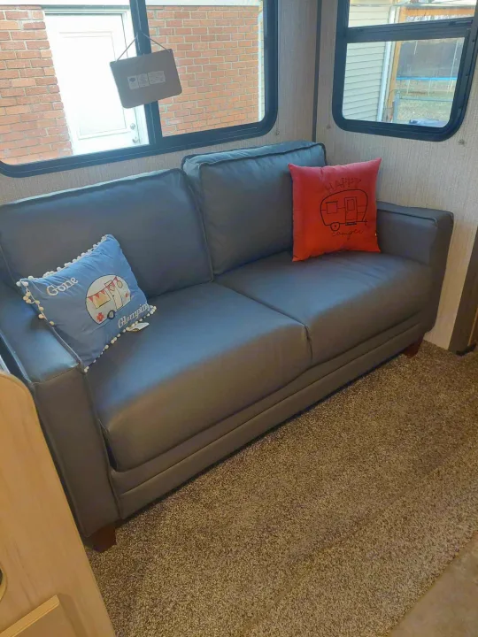 Cozy RV rental interior: gray sofa with "camper" themed pillows on textured carpet. Ready for adventure!. Cruiser RV Radiance Ultra Lite 2020