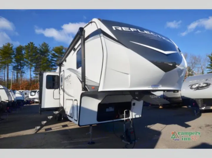 A modern white fifth-wheel RV is parked outdoors with steps down, ready for entry. Ideal for your next rv rental.. Grand Design Reflection 2023