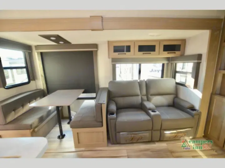 Spacious RV rental interior with a dinette, table, and reclining theater seating. Ideal for comfortable travel.. Grand Design Reflection 2023