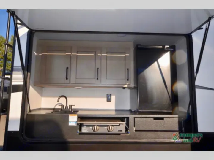 This RV rental offers a spacious outdoor kitchen, complete with a sink, refrigerator, cabinets, and a pull-out griddle.. Grand Design Reflection 2023