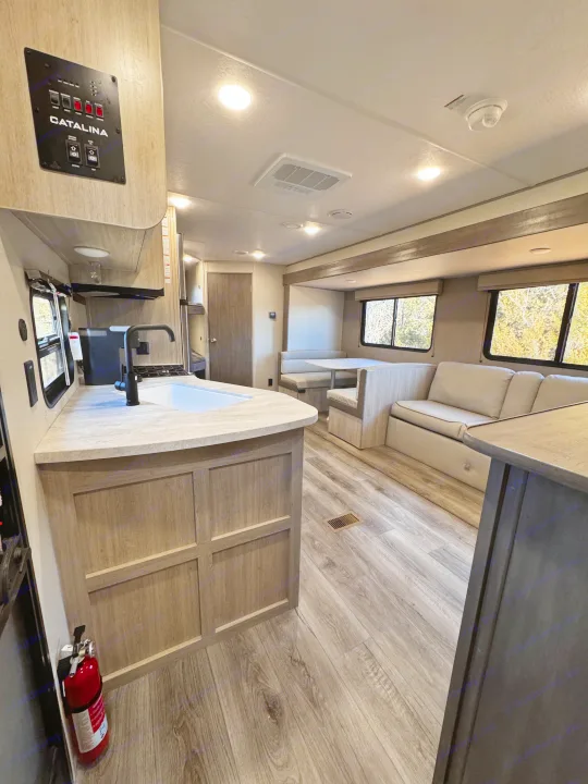 Spacious RV rental interior featuring a kitchen, dinette, and lounge area, ideal for travel.. Coachmen Catalina Summit Series 8 261BHS 2025
