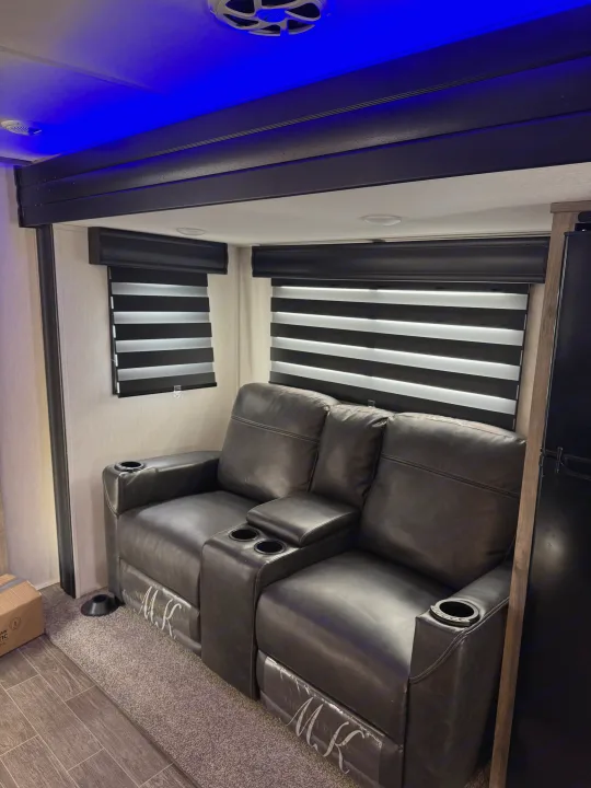 RV rental interior features comfortable black reclining seats with cup holders and cool blue accent lighting overhead.. Forest River Cherokee Alpha Wolf 2022