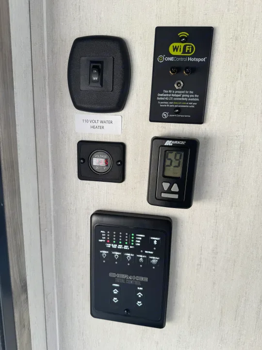 An RV rental's comprehensive control panel: tank levels, voltage, thermostat, water heater, lights, and Wi-Fi hotspot.. Forest River Cherokee Alpha Wolf 2022