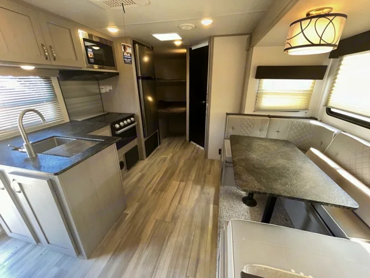 Explore this modern **RV rental** interior! Features a full kitchen, comfortable dinette, and bunk beds for family travel.. Forest River Tracer 2022