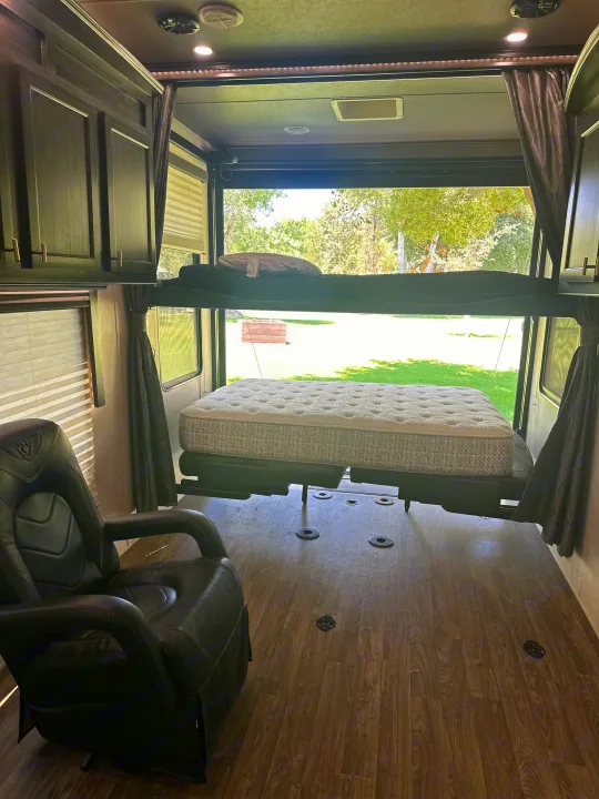 RV rental: Interior of a toy hauler featuring power bunk beds, lower bed, comfortable chair, and open view.. Eclipse Recreational Vehicles Attitude 2020
