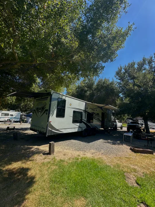 Spacious toy hauler RV rental parked at a shady campsite, perfect for outdoor adventures.. Eclipse Recreational Vehicles Attitude 2020