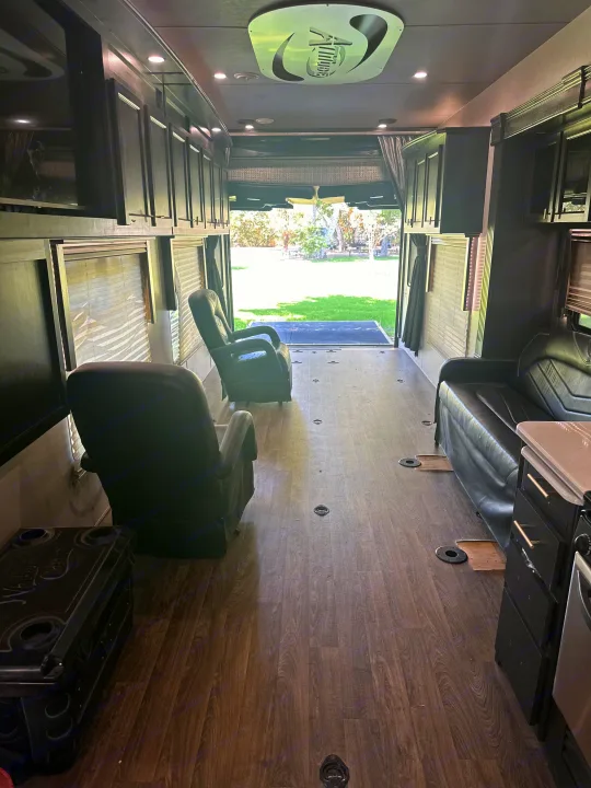 Spacious RV rental interior with recliners, a sofa, and an open ramp leading to a grassy outdoor area.. Eclipse Recreational Vehicles Attitude 2020