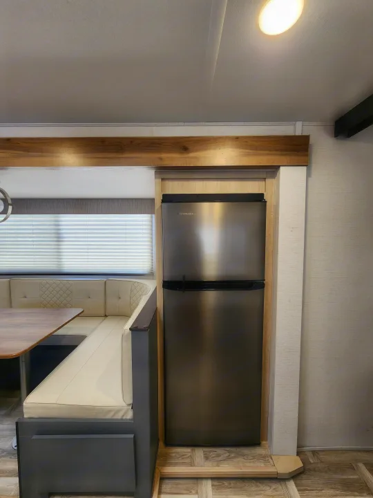 Modern RV rental interior with a compact fridge, cozy dinette, and window blinds. Perfect for travel.. primetime tracer 2024
