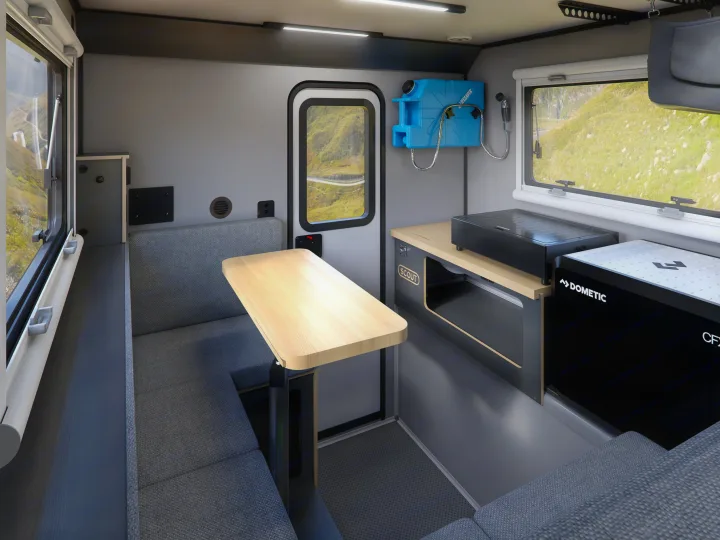 Modern RV rental interior: dining nook, compact kitchen with Dometic fridge, and Lifesaver water tank.. Adventurer 2015 Tacoma 2024
