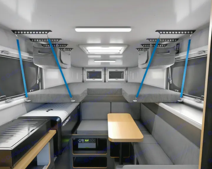 Modern RV rental interior: suspended bunks, dining, and compact kitchen. Ideal for comfortable adventure travel.. Adventurer 2015 Tacoma 2024