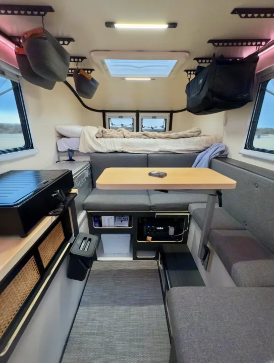 Cozy, organized RV rental interior with bed, kitchen, and dining for travel comfort.. Adventurer 2015 Tacoma 2024