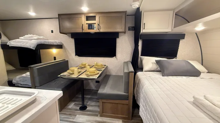 Spacious RV rental interior with a cozy dinette, main bed, and bunk beds, offering comfort for your adventures.. Jayco Jay Flight SLX 175BH 2025