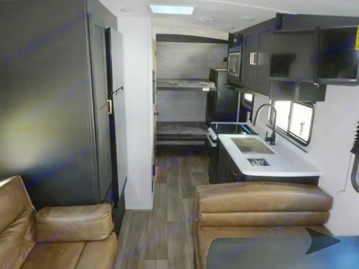 Spacious RV rental interior: modern kitchen, comfortable dinette seating, and rear bunk beds, ideal for your next trip.. Keystone RV Outback Ultra-Lite 2022