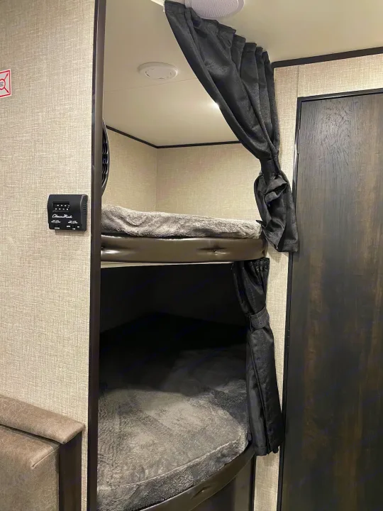 Cozy RV rental interior featuring comfortable bunk beds with privacy curtains, ideal for sleeping on your trip.. Jayco Jay Flight SLX 2022
