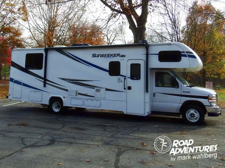 White Sunseeker Class C RV rental with blue/black graphics, parked for travel or camping adventures.. Forest River Sunseeker 2027