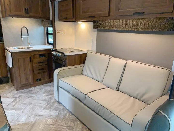This RV rental features a bright, modern interior with a comfortable sofa, well-equipped kitchen, and stylish flooring.. Forest River Sunseeker 2026