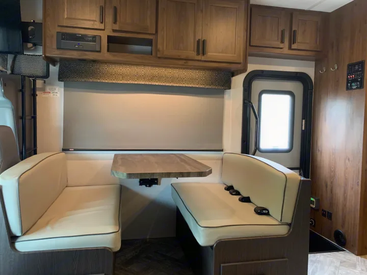 Bright RV rental interior featuring a cozy dinette, modern cabinets, and controls, ready for your next adventure.. Forest River Sunseeker 2026