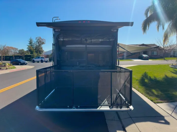 Rear view of a toy hauler RV rental featuring a patio deck, bunk beds, and awning. Ready for your trip!. Forest River Shockwave 2021