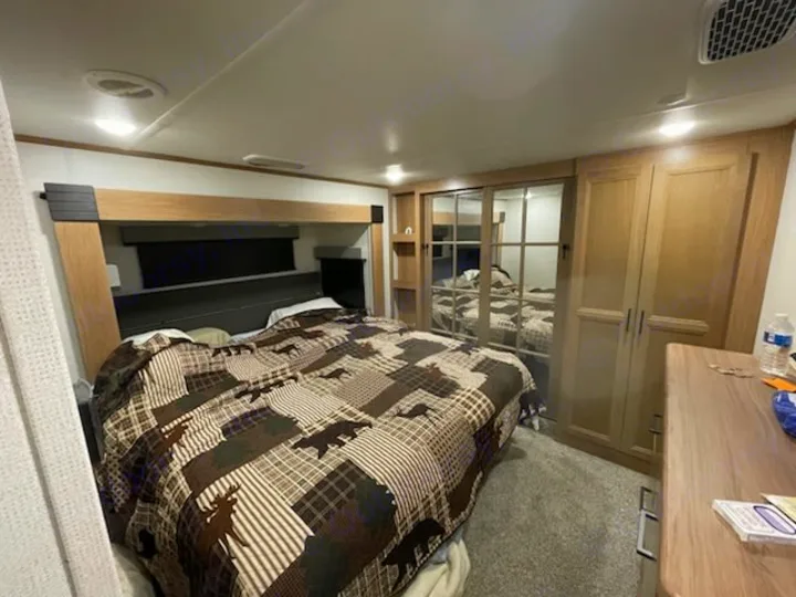 Explore this cozy RV rental bedroom. It features a large bed with a wildlife quilt, mirrored closets, and ample storage.. Prime Time Sanibel 2022