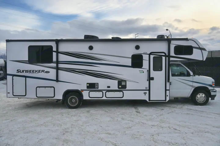A white Sunseeker LE Class C RV rental is parked on snowy ground. Features include dark windows and graphic stripes.. Forest River Sunseeker - LE Series M-2850S 2024