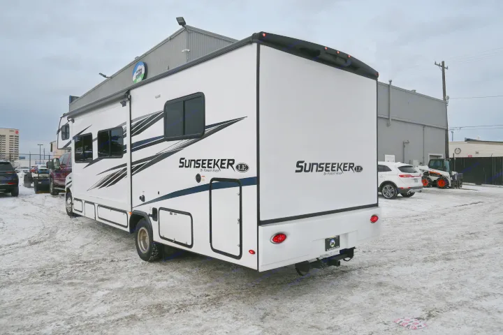 A white Sunseeker RV rental with black graphics is parked on a snowy lot, an Alaska RV dealership visible.. Forest River Sunseeker - LE Series M-2850S 2024