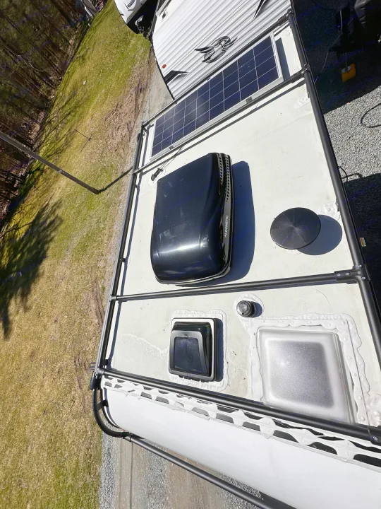 Top-down view of an RV rental roof featuring solar panels, a Dometic AC unit, vents, and a roof access rack.. Winnebago Other 2023