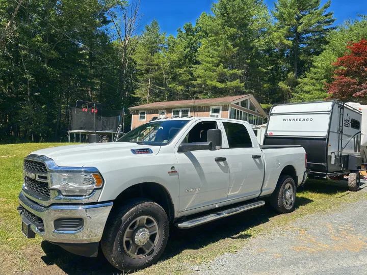 White Ram truck towing Winnebago RV trailer on a sunny day. Perfect setup for an RV rental adventure!. Winnebago Other 2023