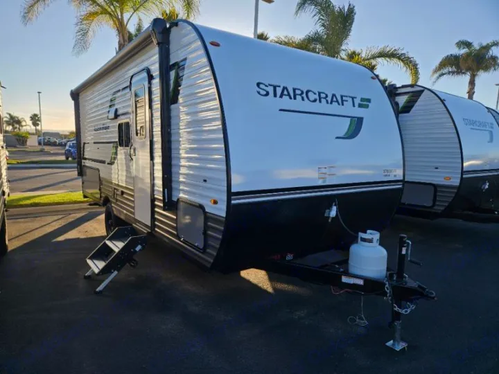Explore with this Starcraft RV rental! A white and black travel trailer, awning extended, steps down, ready for your next trip.. StarCraft 188BHS 2025