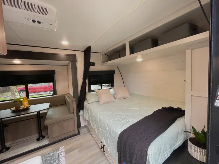 Discover a bright rv rental interior with a bedroom, dining booth, and overhead storage.. StarCraft 188BHS 2025