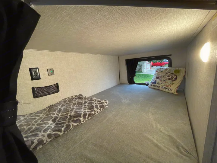 Cozy RV rental bunk bed area, complete with a window, charging port, power outlet, and storage net.. StarCraft 188BHS 2025