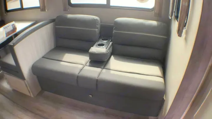 RV rental interior: Comfortable grey sofa with integrated cup holders & dinette seating area.. Coachmen Catalina 2021