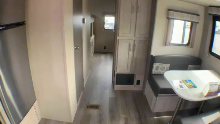 Explore the comfortable interior of this RV rental, showcasing a light wood floor, dinette, and bright hallway. Ideal camper living!. Coachmen Catalina 2021