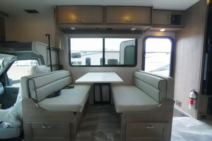 Inside an RV rental: a modern dinette and spacious cab-over bed area, ready for comfortable travel.. Gulf Stream Conquest 2024