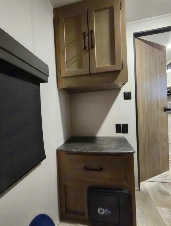 RV rental: Modern interior featuring wood-tone cabinets, counter, window blind, and outlets for comfortable compact living.. Palomino Puma 2024