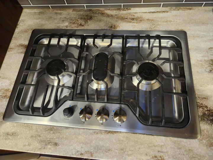 Stainless steel Furrion gas cooktop with 3 burners & center griddle in an RV rental.. Prime Time Lacrosse 2019
